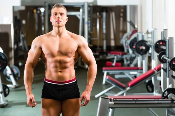 Culturista posando en gimnasio —  Fotos de Stock