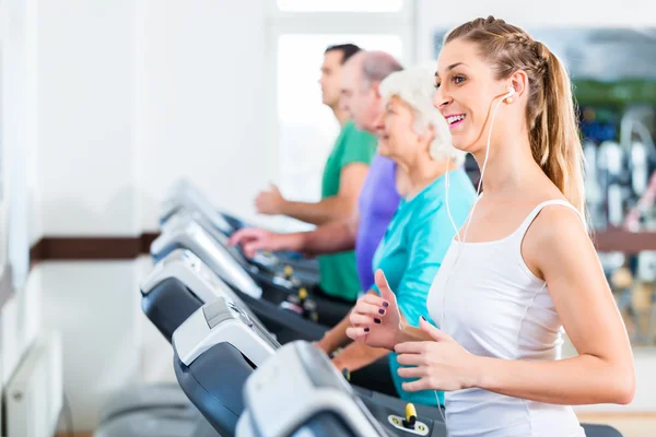 Grupp med ledande personer på löpband i gym — Stockfoto