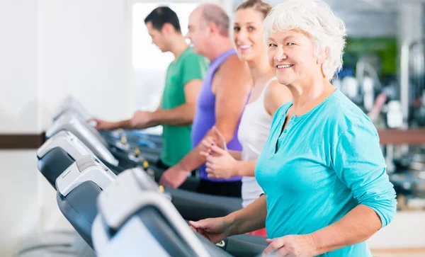 Grupp med ledande personer på löpband i gym — Stockfoto