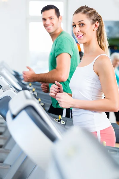 Man och kvinna på elliptical tränad i gym — Stockfoto