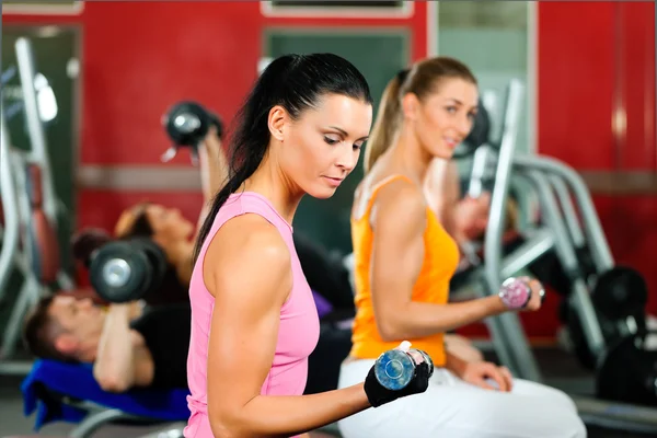 Människor i gym tränar med vikter — Stockfoto