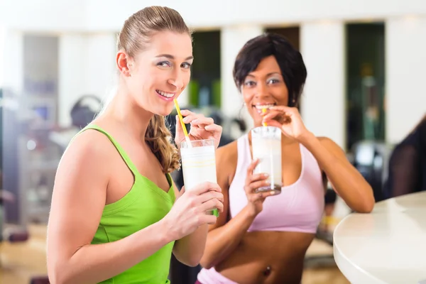 Mujeres en el gimnasio bebiendo una bebida isotónica —  Fotos de Stock