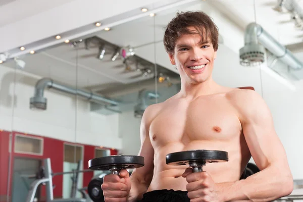 Sport - man is exercising with barbell in gym — Stock Photo, Image