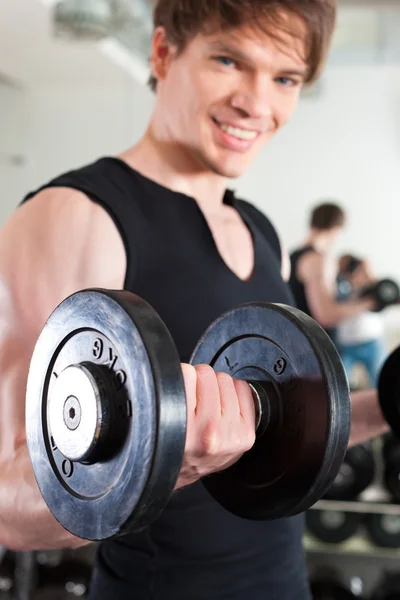 Sport - man is de uitoefening met barbell in gym — Stockfoto