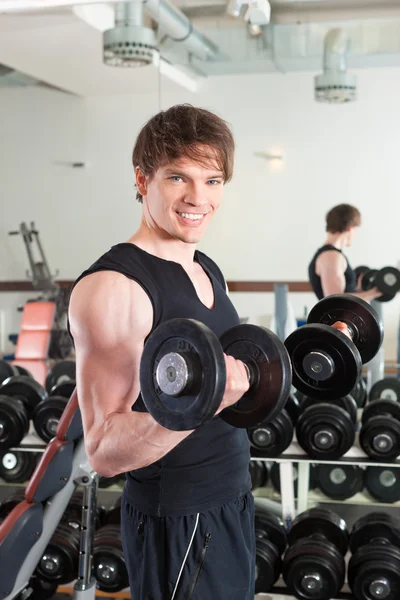 Sport - man is exercising with barbell in gym — Stock Photo, Image