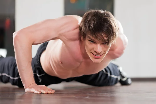 Man doing pushups in gym — Stock Photo, Image