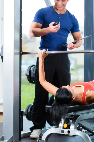 Woman and Personal Trainer in gym — Stock Photo, Image