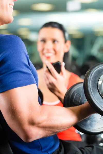 Personal Trainer in gym and dumbbell training — Stock Photo, Image