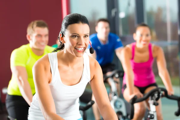 Unga människor Spinning i gymmet fitness — Stockfoto