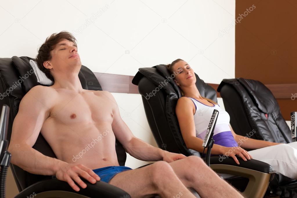 Couple on massage chair in gym