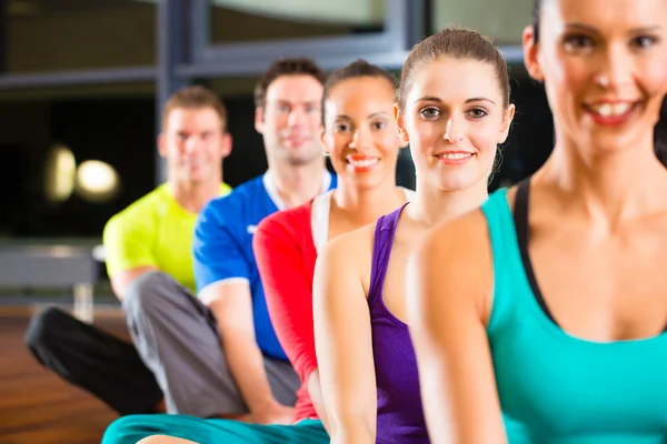 Group of people and instructor in gym stretching Stock Picture