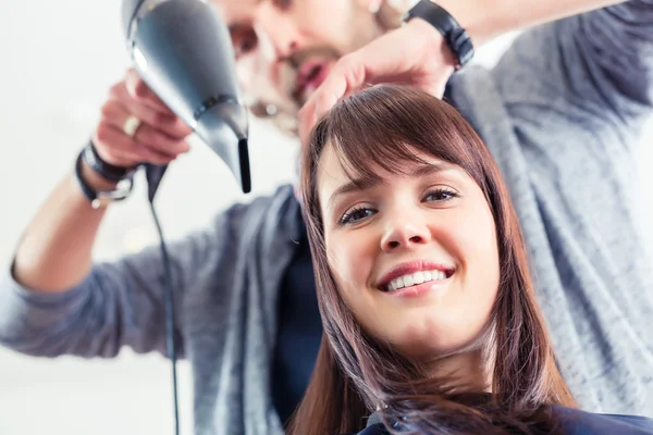 Friseur föhnt Frau die Haare im Geschäft — Stockfoto