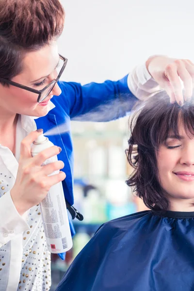 Парикмахер укладки женские волосы в магазине — стоковое фото