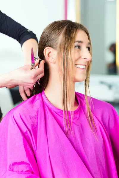 Mujer que recibe corte de pelo de estilista o peluquero — Foto de Stock