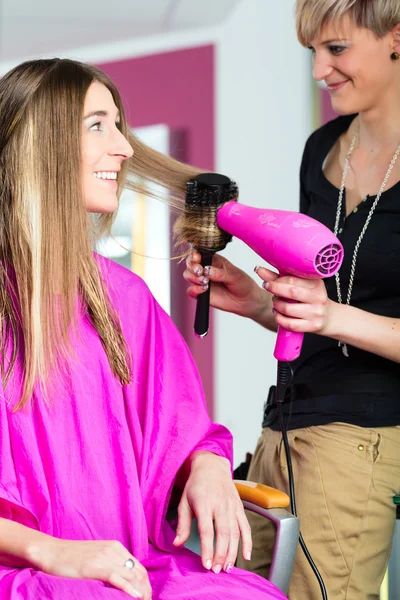 Woman at the hairdresser with blow dryer — Stock Photo, Image