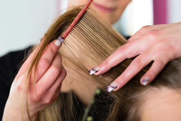 Mujer recibiendo corte de pelo en peluquería tienda — Foto de Stock