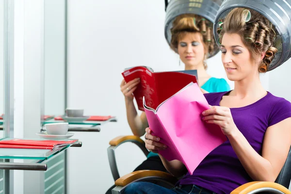 Women at the hairdresser with hair dryer — Stock Photo, Image