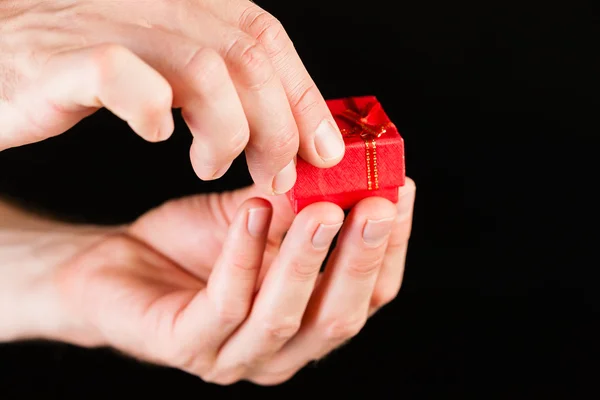 Mano que muestra la caja presente roja — Foto de Stock