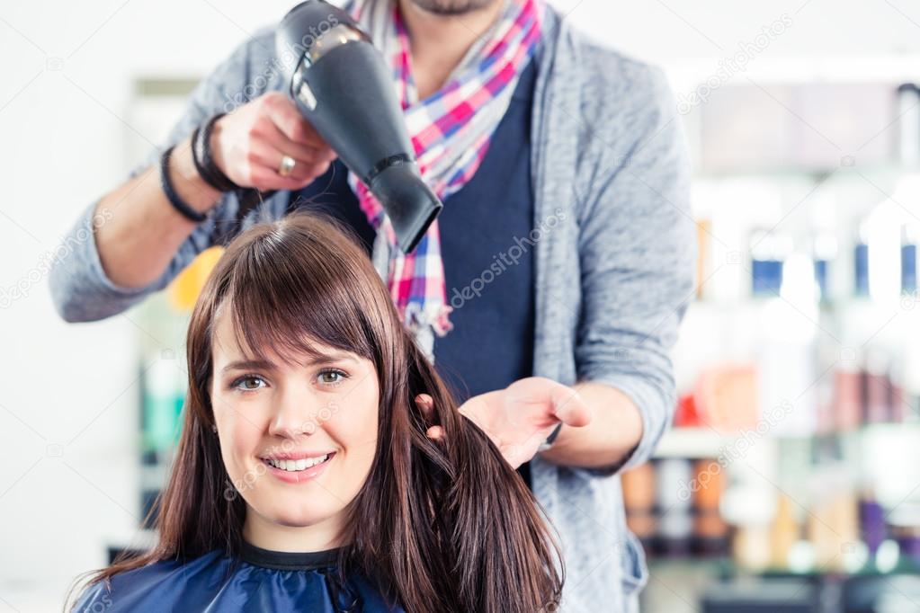 Hairdresser blow dry woman hair in shop