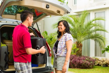 couple packing car with suitcases for holiday clipart