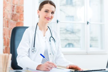 Kadın doktor belgede yazıyor.