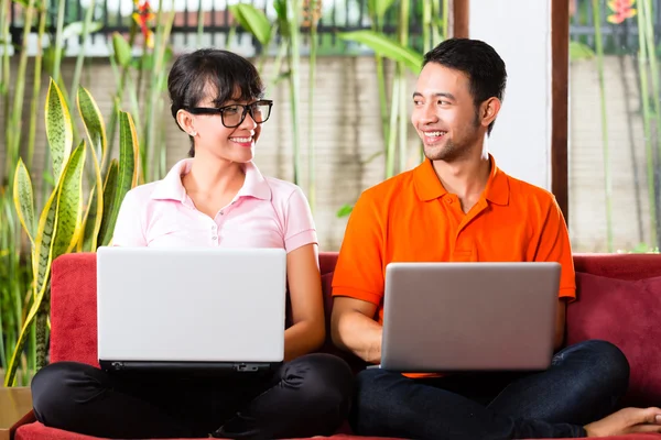 Asiática pareja en el sofá con un ordenador portátil —  Fotos de Stock