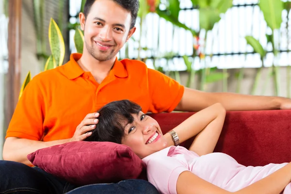 Asian couple in spacious home on sofa — Stock Photo, Image