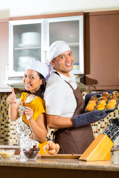 Asiático pareja hornear muffins en casa cocina — Foto de Stock