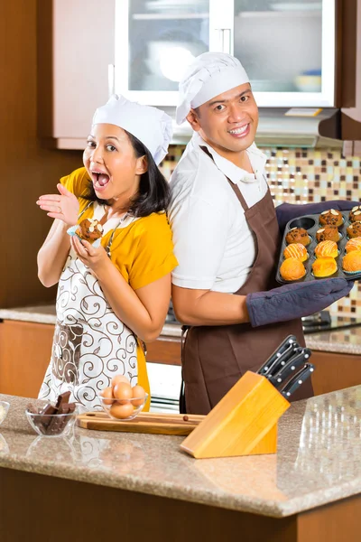 Asiático pareja hornear muffins en casa cocina — Foto de Stock