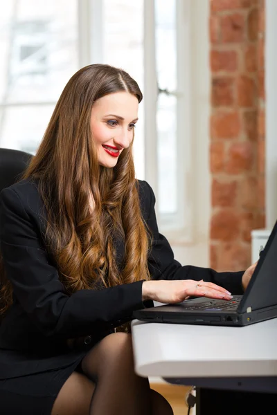 Woman in office sitting on the computer — Stockfoto
