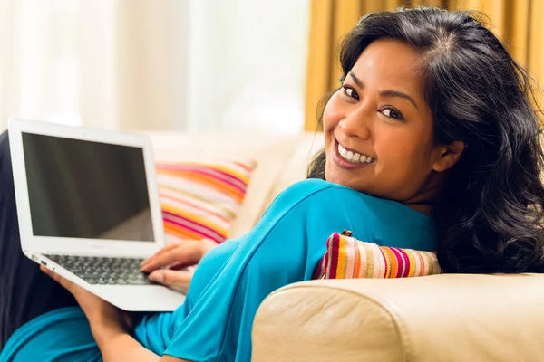 Asiatin surft im Internet und lächelt — Stockfoto