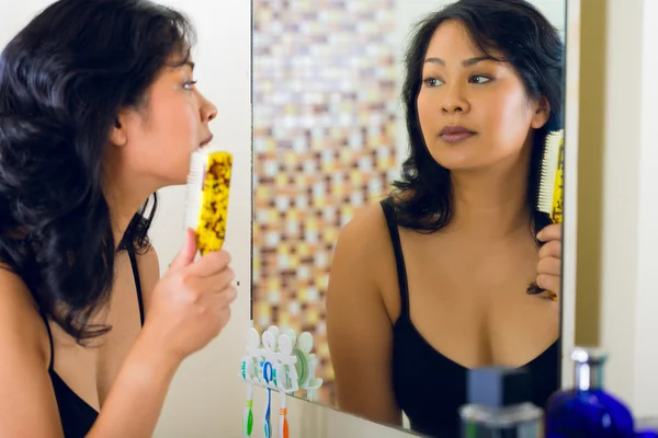 Asiatico donna pettinatura capelli in bagno specchio — Foto Stock