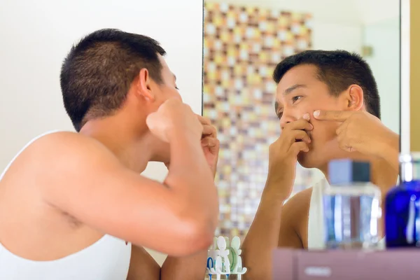 Hombre asiático descubriendo un grano en la cara — Foto de Stock
