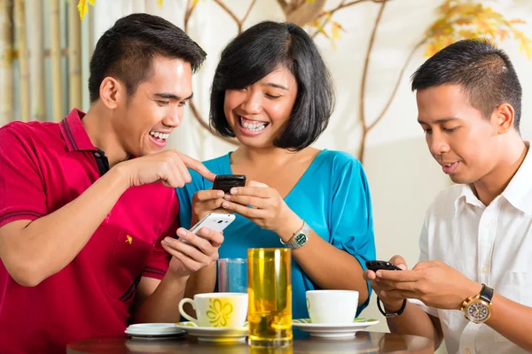 Gente asiática divirtiéndose con teléfono móvil — Foto de Stock