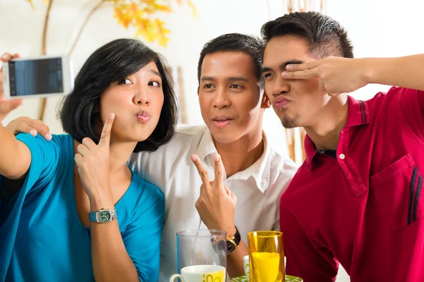Amigos asiáticos tomando fotos con teléfono móvil —  Fotos de Stock