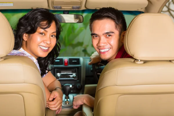 Asiática pareja sentado en coche — Foto de Stock