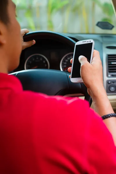 Ásia homem texting enquanto condução — Fotografia de Stock