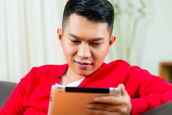 Young Asian man at home on the sofa — Φωτογραφία Αρχείου