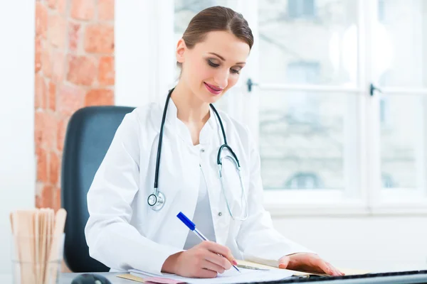Kobieta lekarz pisząc w dokumencie — Zdjęcie stockowe