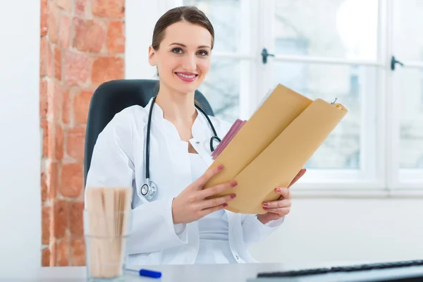 Female doctor reading in document — Stok fotoğraf