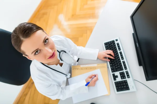 Ärztin schreibt in Dokument — Stockfoto