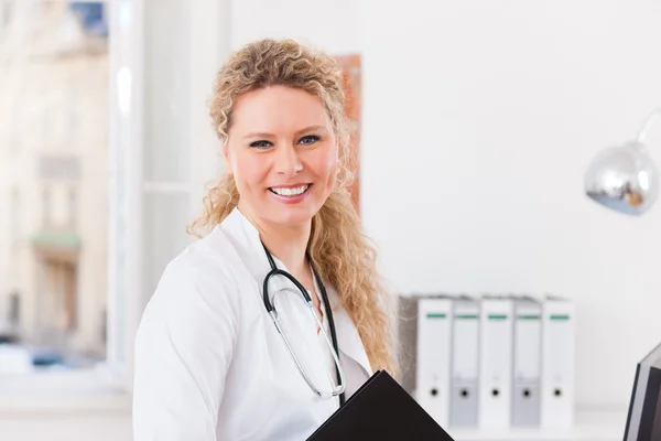 Joven doctora en clínica con archivo — Foto de Stock