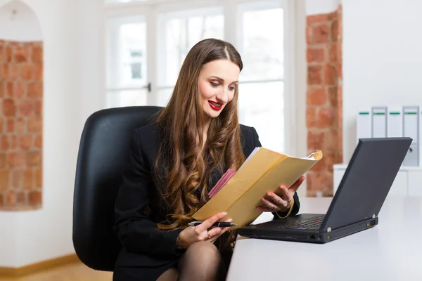 Woman in office sitting on the computer — Stock Photo, Image