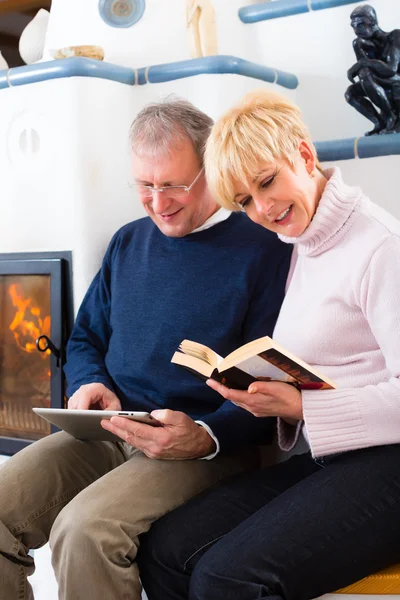 Senioren zu Hause vor dem Kamin — Stockfoto