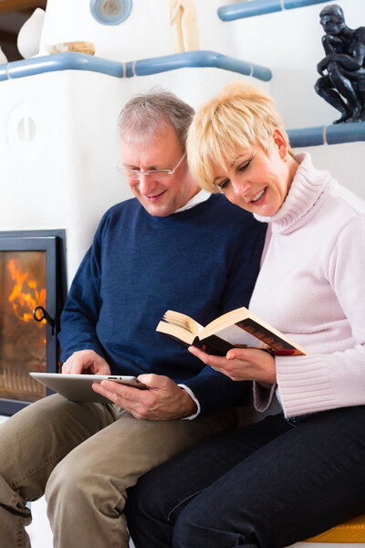 Seniors at home in front of fireplace