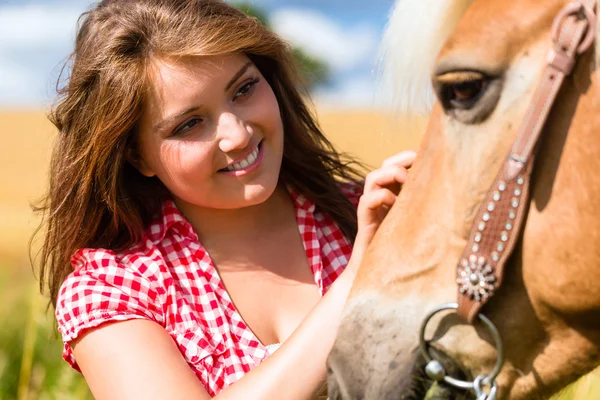 Женщина гладит лошадь на пони-ферме — стоковое фото