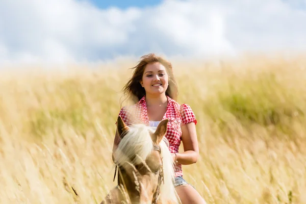 Vrouw rijden op paard in zomer weide — Stockfoto