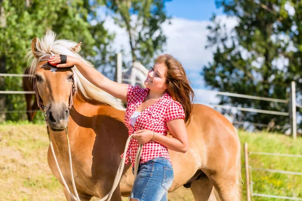 Frau kämmt Pony auf Pferdestall — Stockfoto