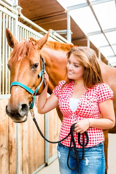 De toonaangevende pony vrouw in paard stabiel — Stockfoto