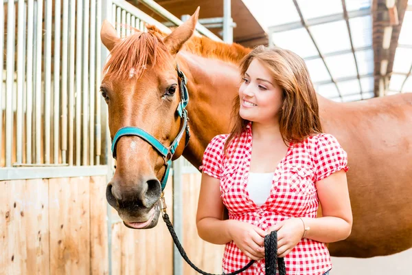 Mulher levando pônei no estábulo cavalo — Fotografia de Stock